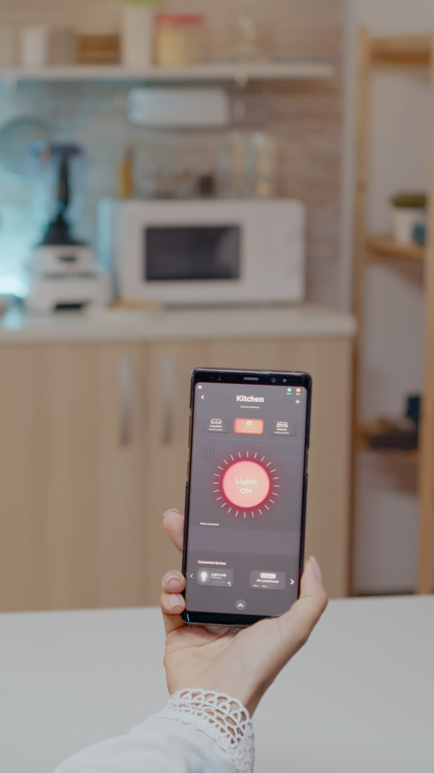 Person looking at mobile phone with lighting controlling app sitting in kitchen of house with automation light system, turning on bulb using voice command. Woman monitoring electricity effiency